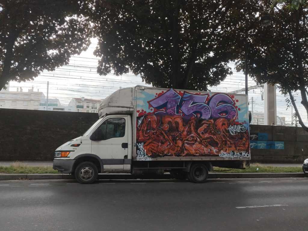 Graffiti auf Lastwägen. Im Bild ein von STESI als organischer, bzw. biomechanischer Stil beschriebene Gestaltung eines Lastwagens. Oben drüber ein gut lesbares "156"-Graffiti, einer der ältesten Graffiti-Crews von Paris.