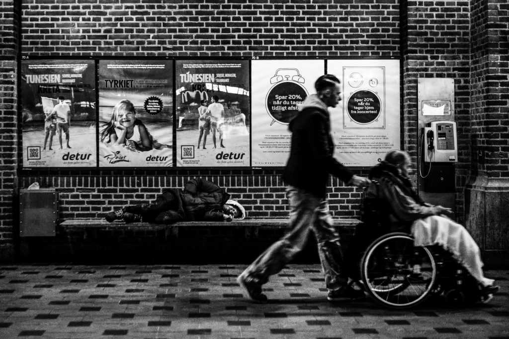 Die inklusive Stadt, Achtsamkeit, Journalismus urbane Plattform, Mensch im Rollstuhl und Begleiter, sowie eine Obdachlose Person Hintergrund, Medienprojekt reisende der Städte Urbanauth, schwarzweiß Bild, Dänemark, Kopenhagen